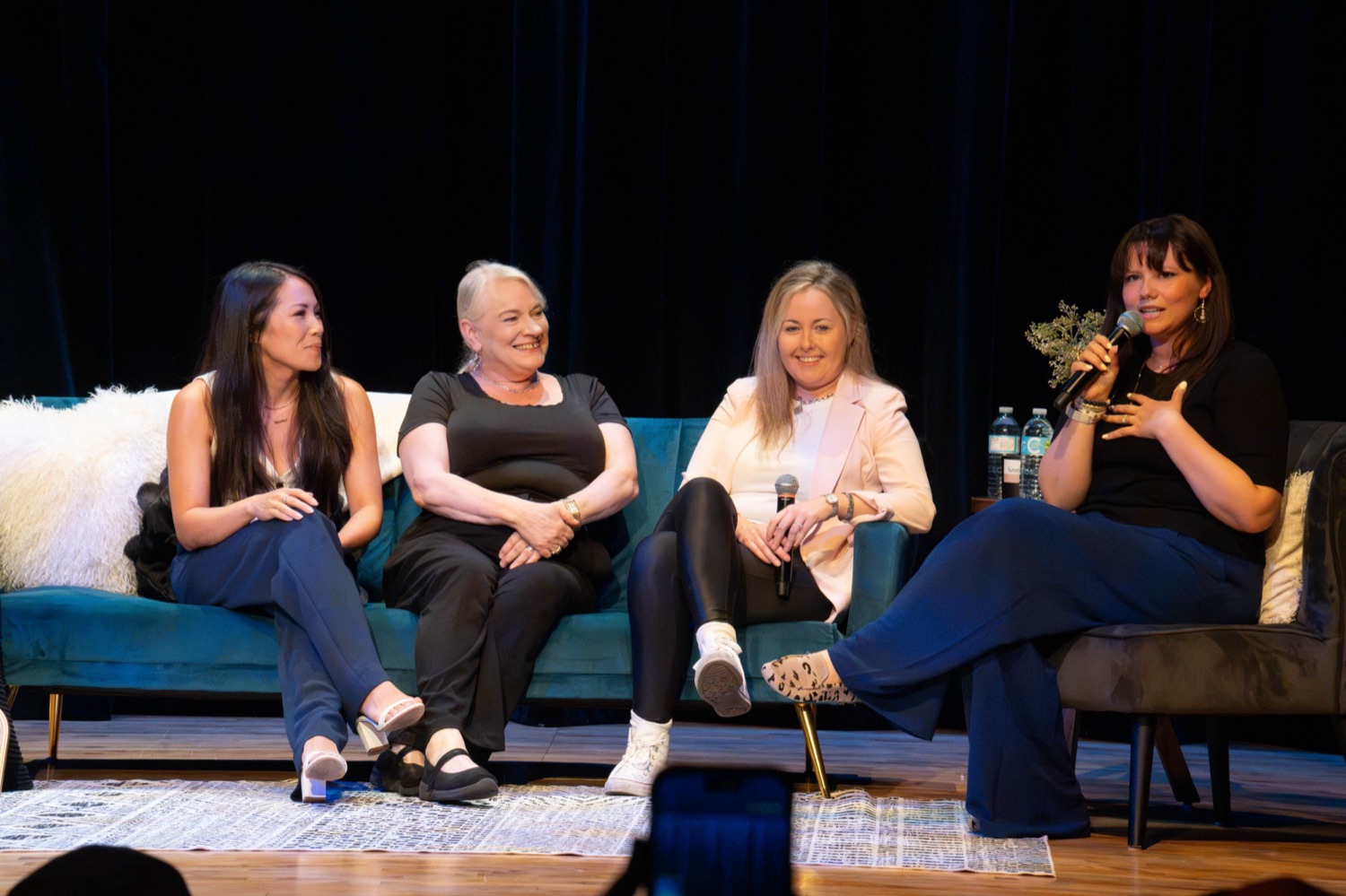 Brooke speaking with three women seated on a teal sofa at the HER. launch